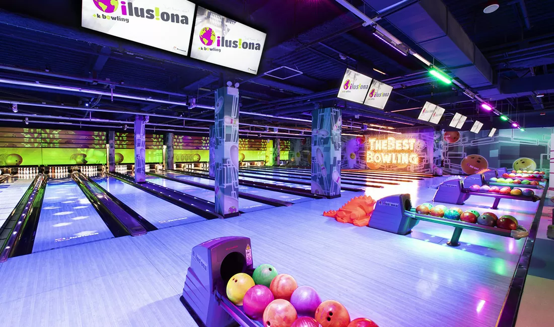 multiple bowling lanes with tv screens and ball returns